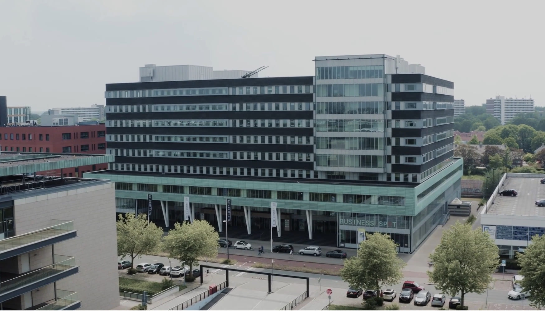 Modern kantoorgebouw met glazen gevel aan een plein